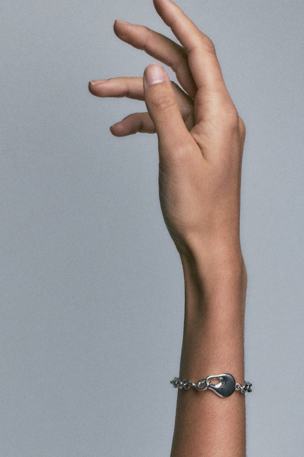 FF Bracelet in 925 silver, oval links with a smooth teardrop station, on a raised wrist.