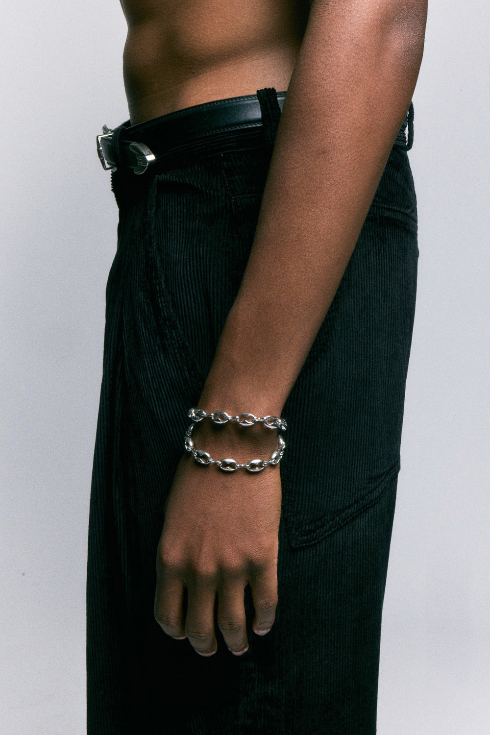 Kabocha Bracelet in 925 silver, puffed oval links at the wrist, worn with black corduroy trousers.
