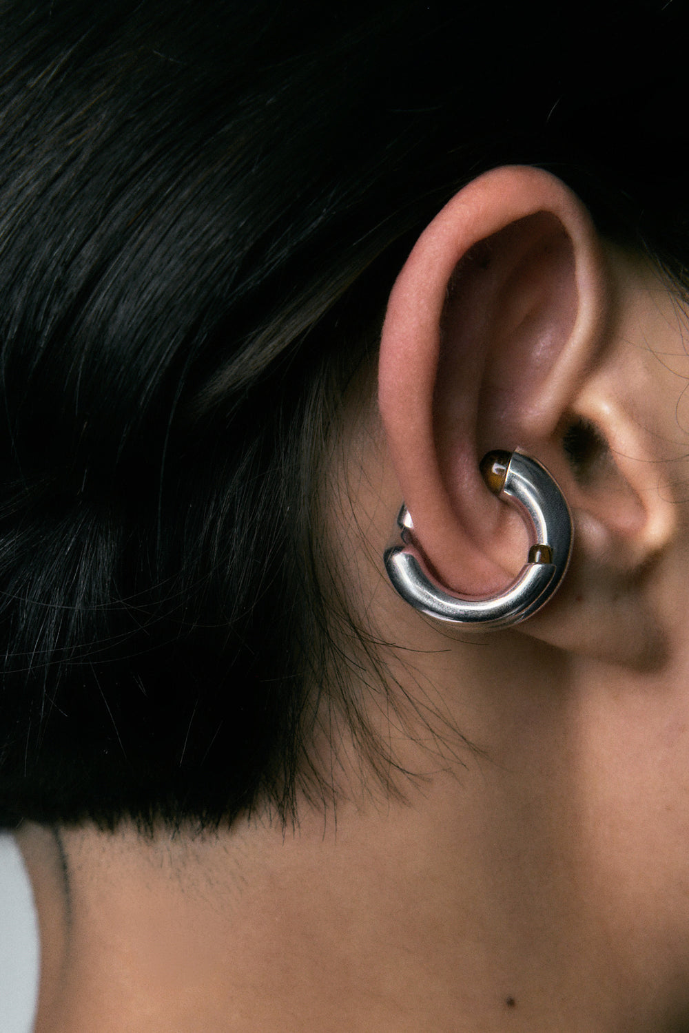 Mushroom Ear Cuff in 925 silver, a thick C-curve clasped over the ear rim, close view.
