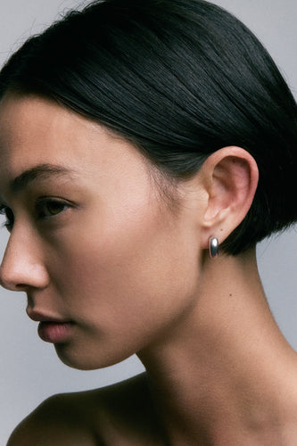 Onion Earrings in 925 silver, a small domed huggie hoop on the lobe, side profile.
