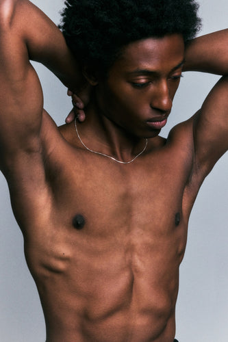 Box Chain in 925 silver at the collarbone, arms raised behind the head.