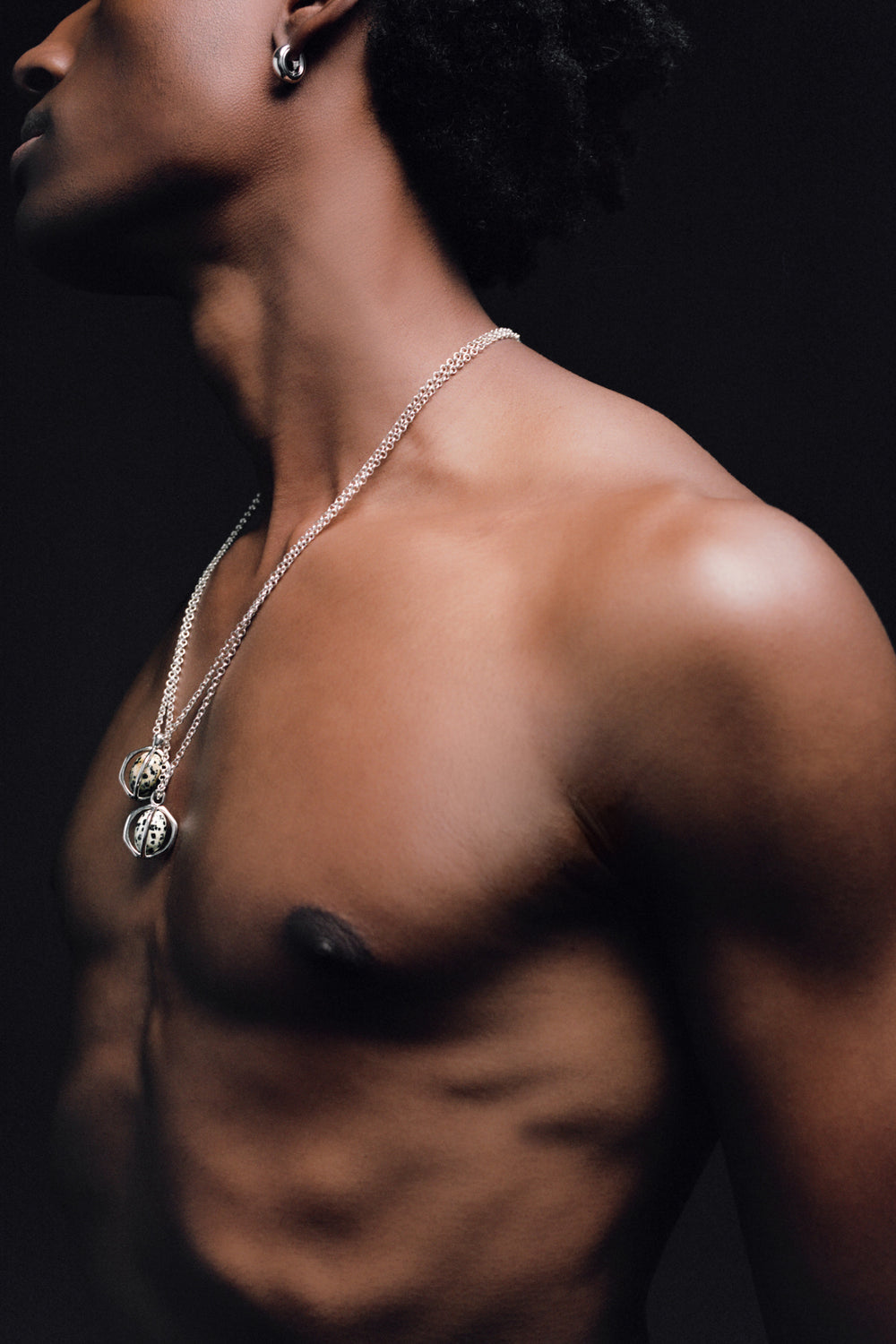 Quail Egg Necklace in 925 silver, two pendants layered on fine chains against a dark ground.
