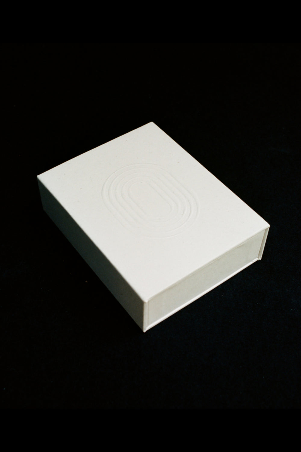 INO white gift box with embossed logo, magnetic closure, shown against black background — included with every order
