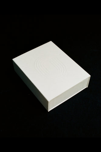 INO white gift box with embossed logo, magnetic closure, shown against black background — included with every order