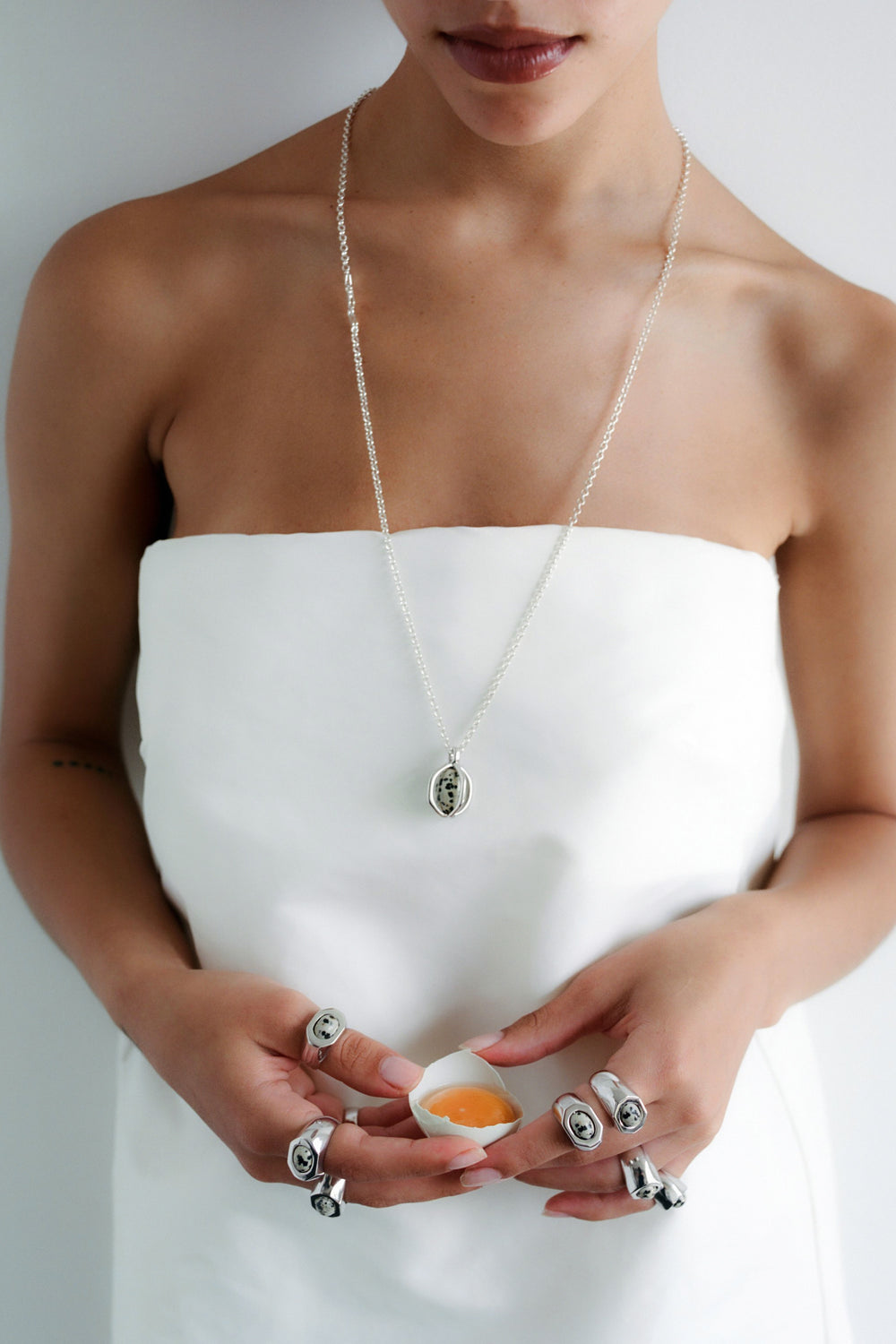Quail Egg Ring in 925 silver worn while holding a cracked egg, with the Quail Egg Necklace.