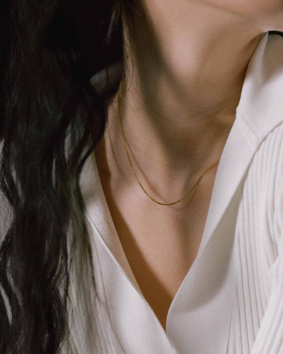 model wearing 1mm box chain in solid 14k yellow gold